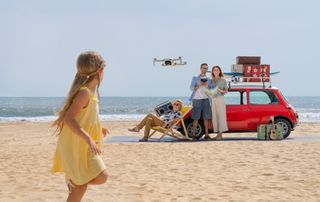 Family on a beach, flying a DJI Mini 2 drone