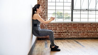 Woman performing wall sit exercise