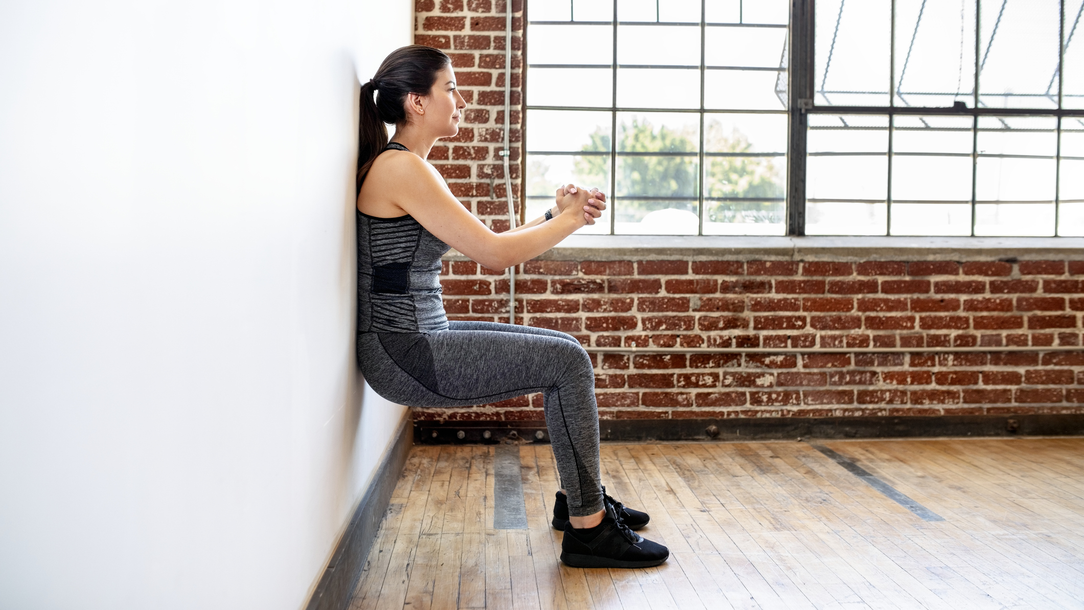 Woman performing wall sit exercise