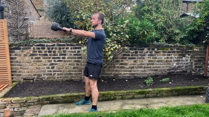 Man in the middle of a set of kettlebell swings