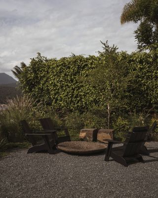 Dark colored Adirondack chairs in a backyard