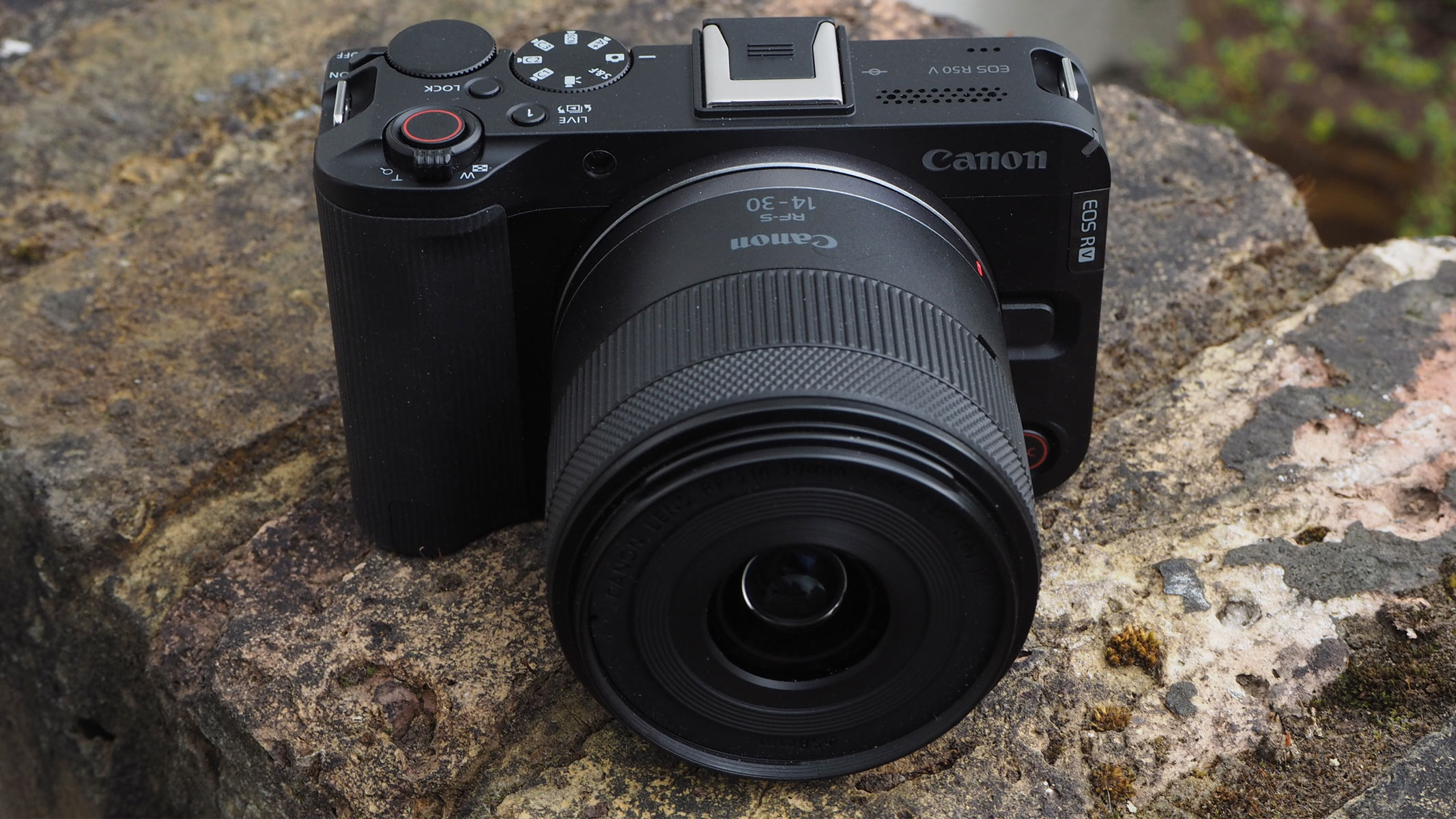 The Canon EOS R50 V on a brick wall, bird&#039;s eye view.