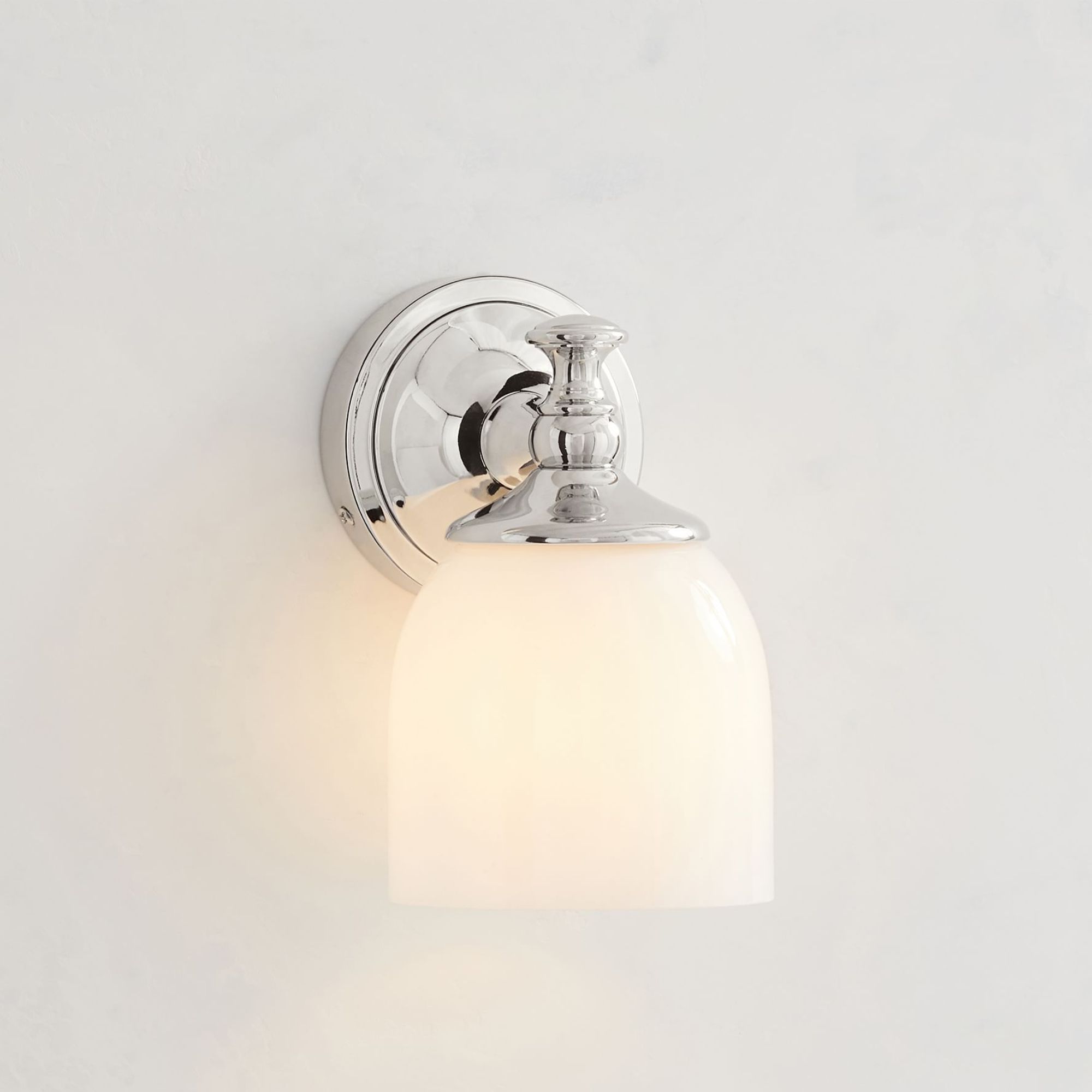 Polished nickel wall sconce with frosted glass shade