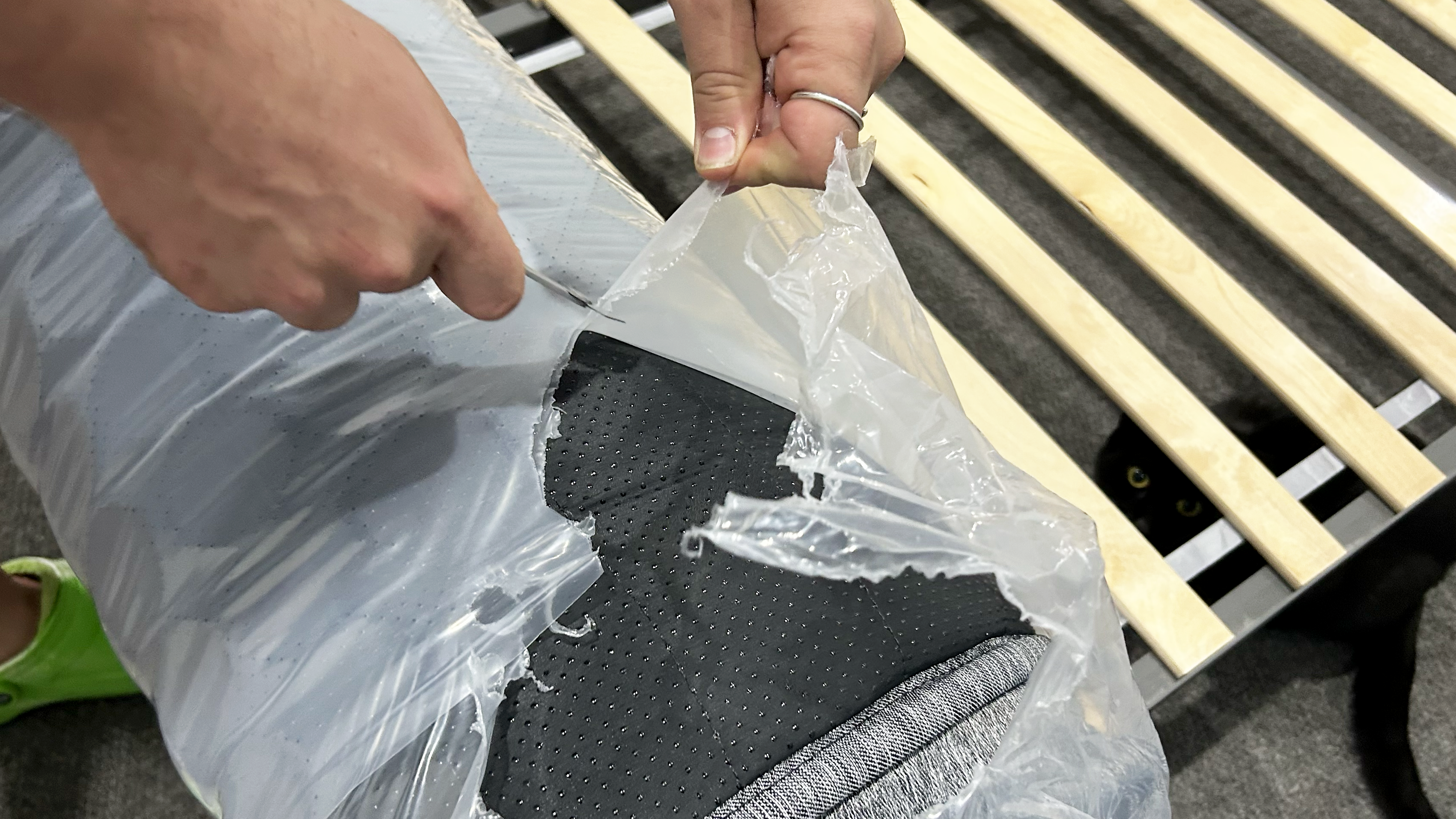 Hands opening plastic with cat in background