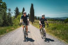 Emma Magnus riding alongside an instructor on a white road in Tuscany
