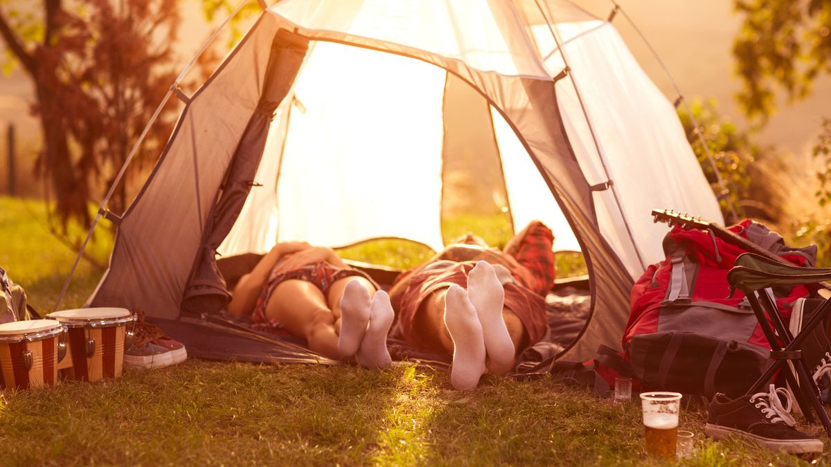 Couple relaxing in a tent with a guitar and bongos in shot