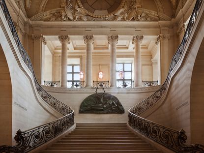 Marble staircase with wrought iron ballistrade leading to upper floor of Care Mollen restaurant