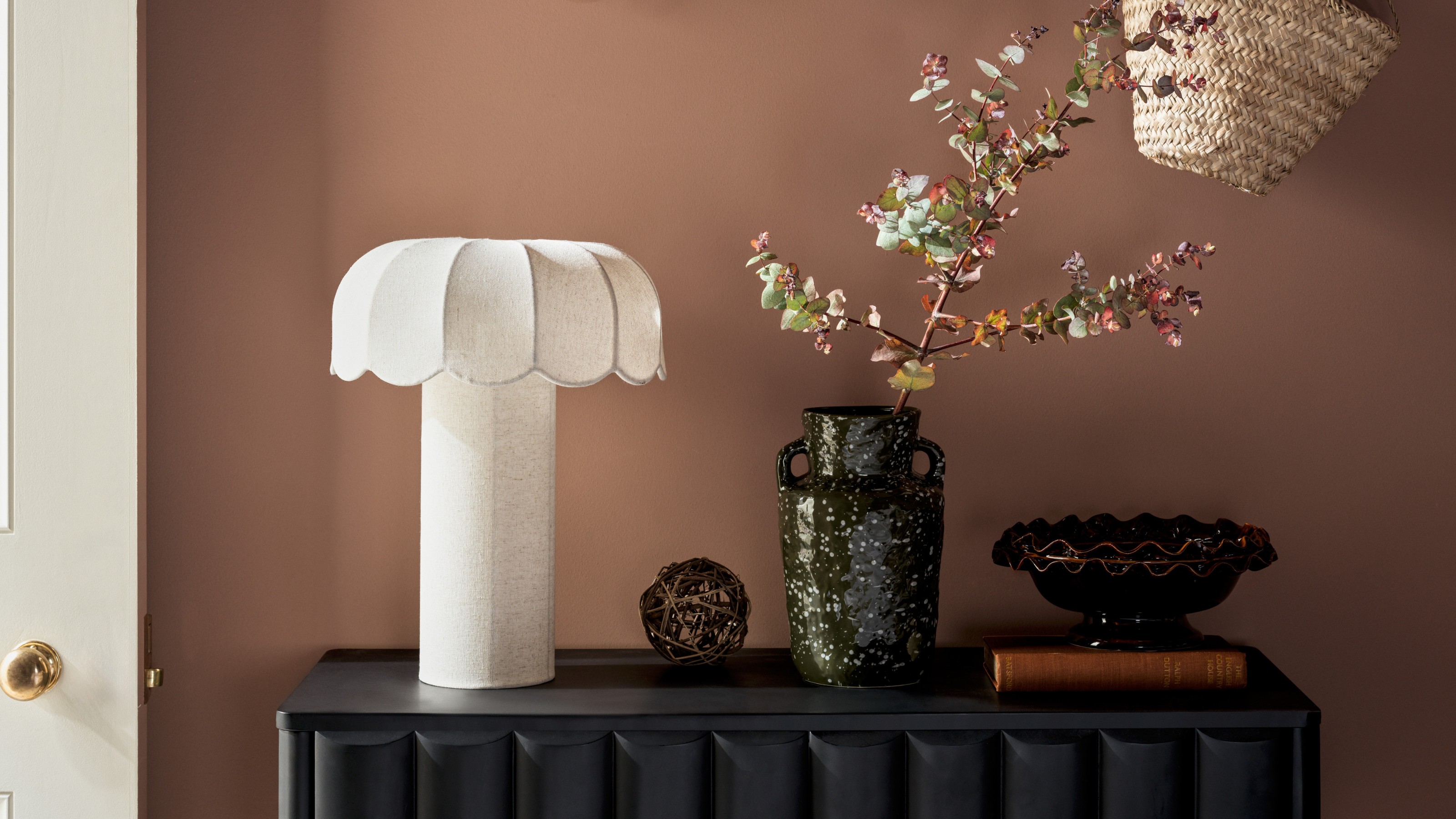 A hallway with a panelled black console table and the M&amp;S Skeletal Petal Dual Lit Table Lamp on top