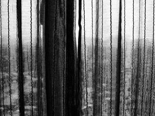 Black and white photograph showing aclose up of translucent curtains.