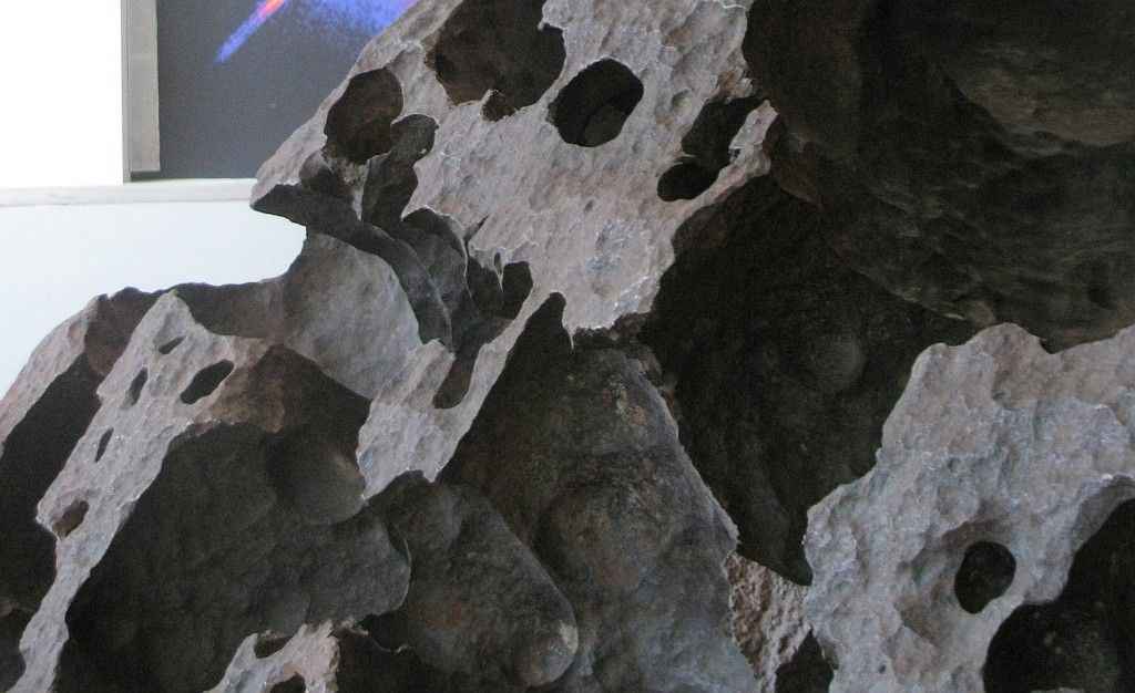 Surface detail of the Tomanowos meteorite, showing cavities produced by dissolution of iron.