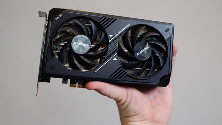 An Nvidia RTX 5060 held in a masculine hand