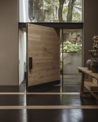 An earth-toned entryway with door on a pivot