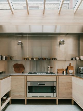 light kitchen with pale wood cabinets and stainless steel countertop