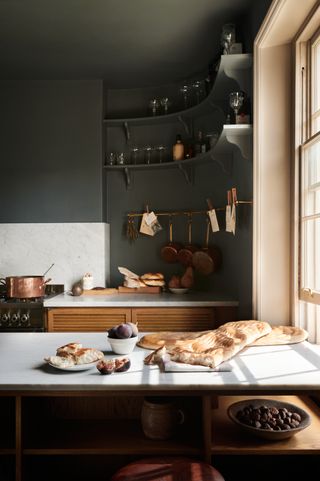 curved shelving in a kitchen with dark grey walls by deVol