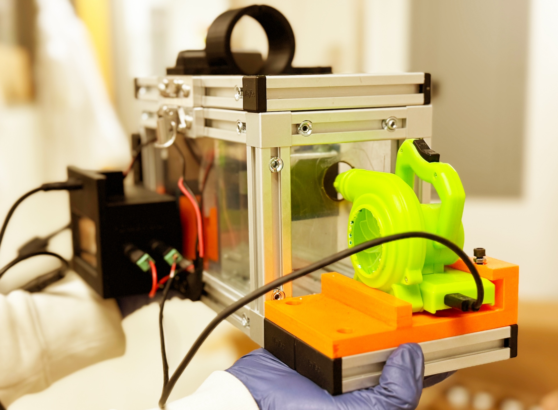 a researcher holds up a prototype of a breathalyzer device that detects diseases