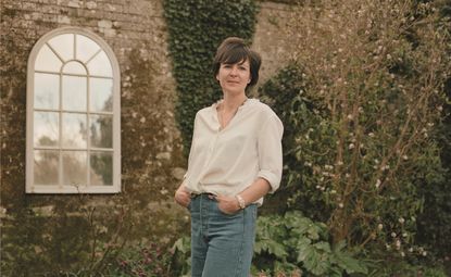 woman in white shirt and blue jeans standing in garden
