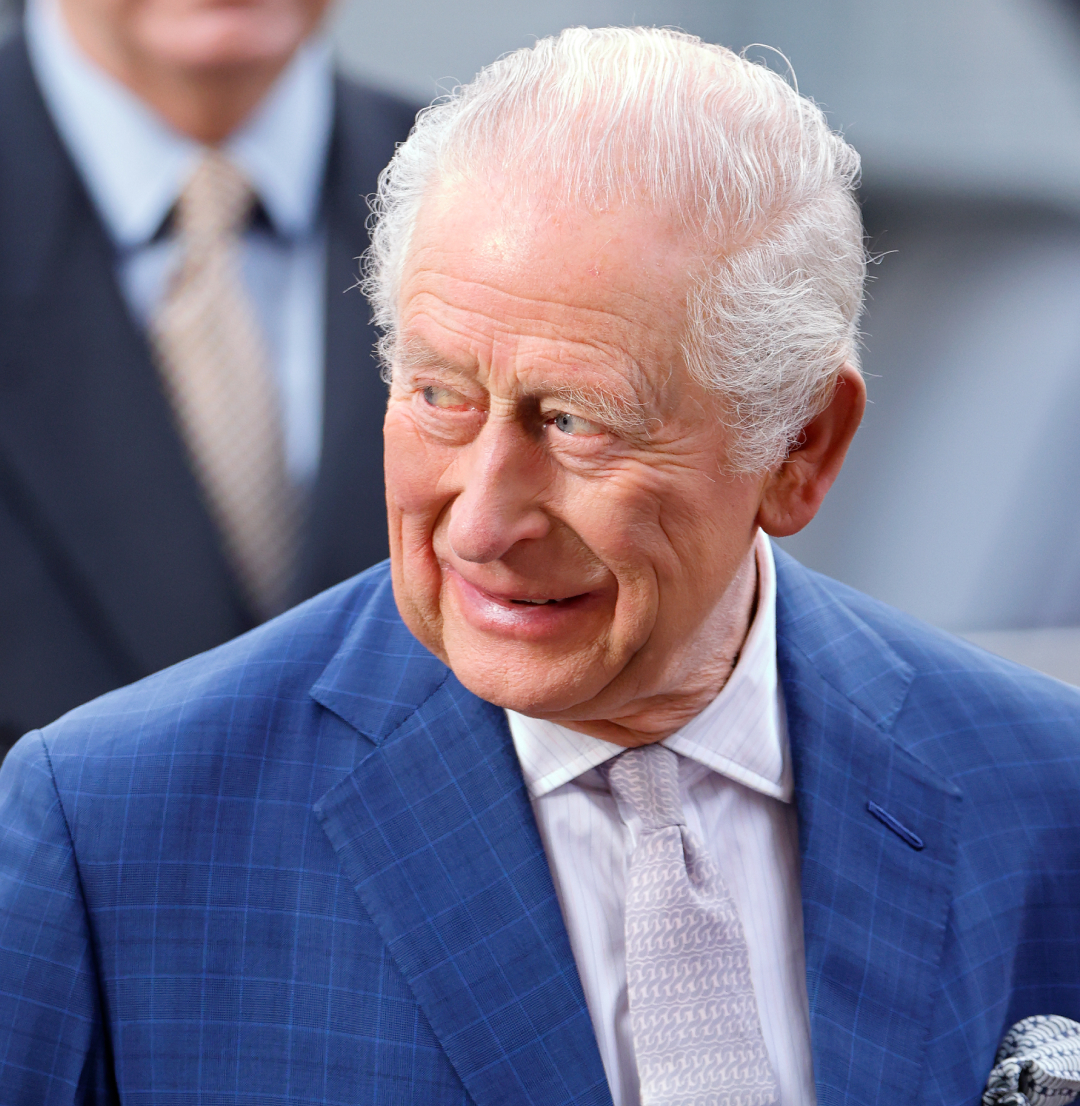 King Charles wearing a blue suit and smiling