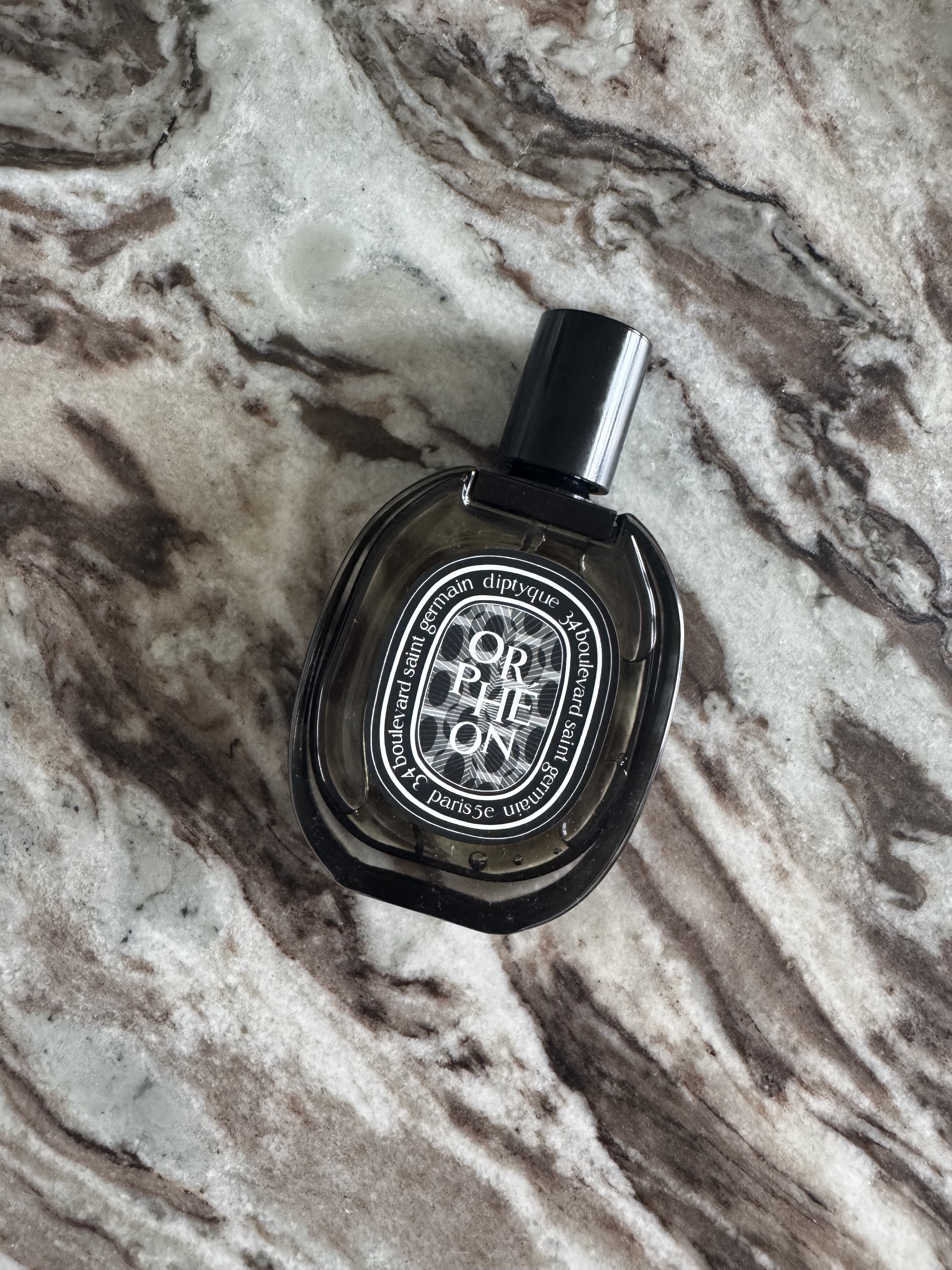A bottle of Diptyque Orpheon on a marble table