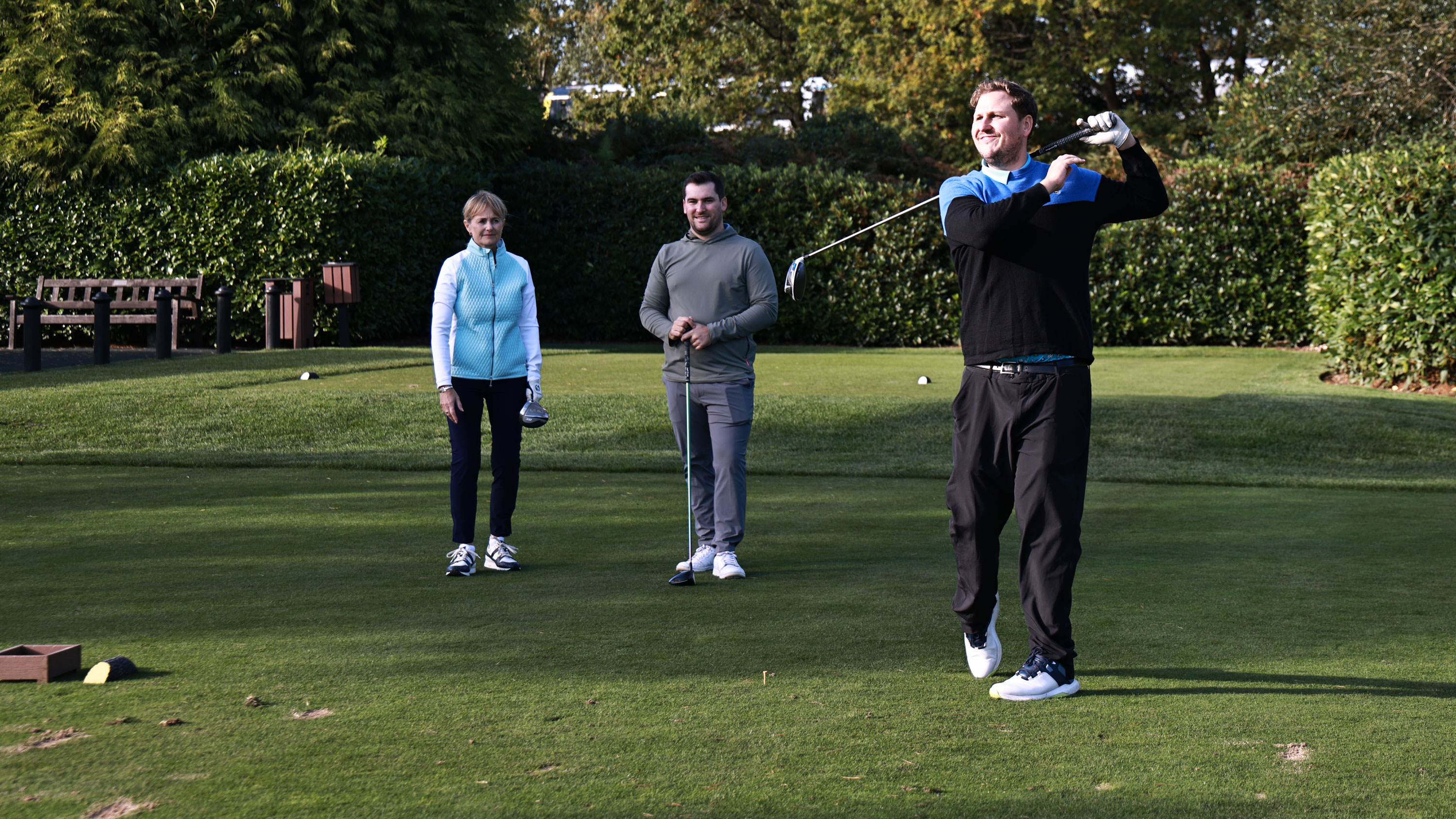 golfer teeing off the 1st tee looking unhappy with playing partners behind