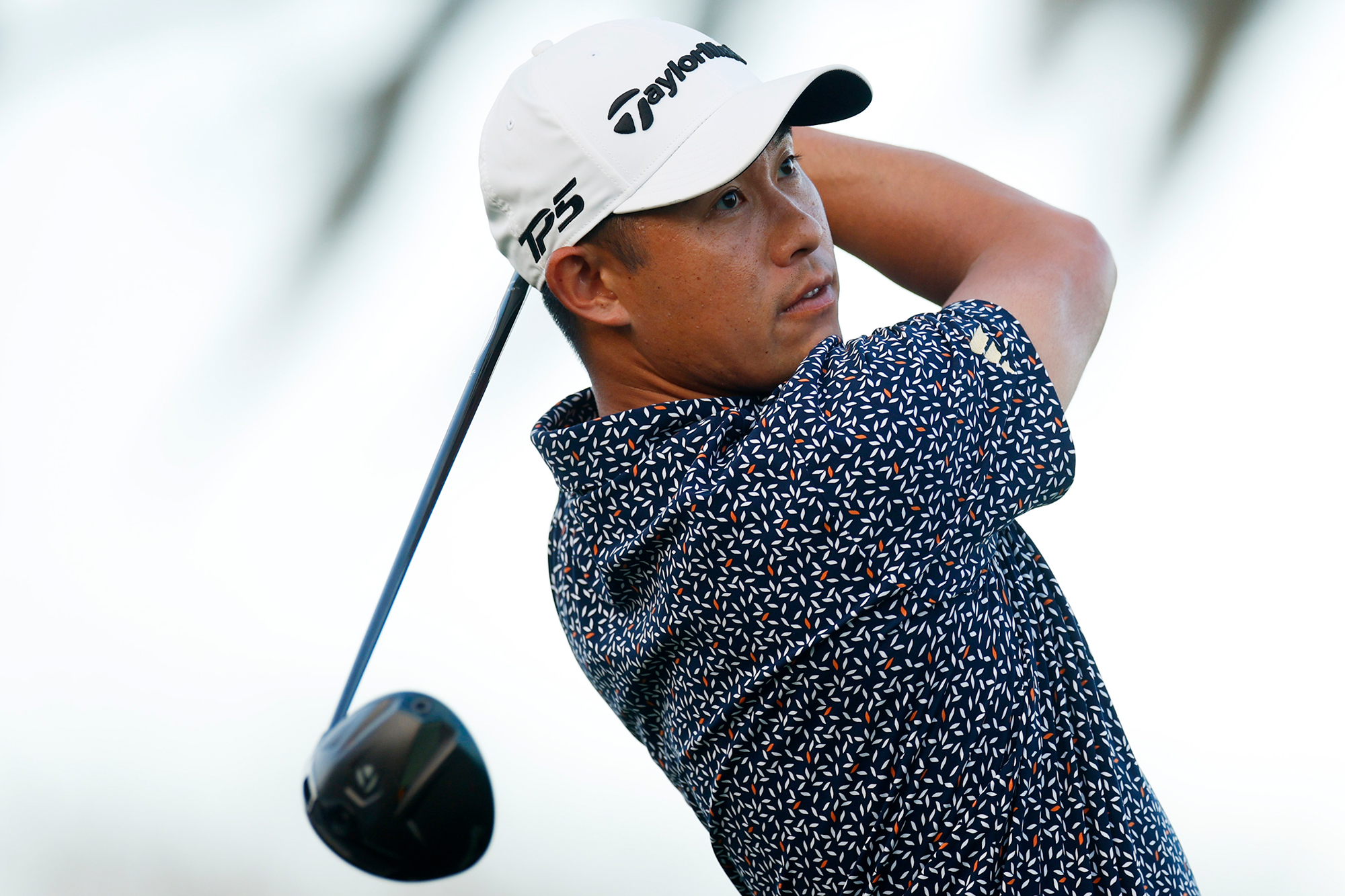 Collin Morikawa in the finish position with driver watching his golf ball in flight