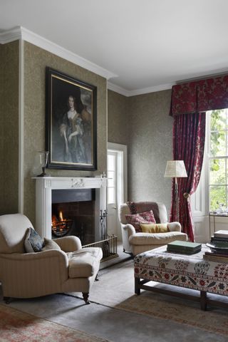 living room with olive wallpaper and claret curtains and valance, armchairs, open fire, table lamps