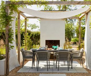 pergola with drapes and climbing plants above Bridgman outdoor furniture