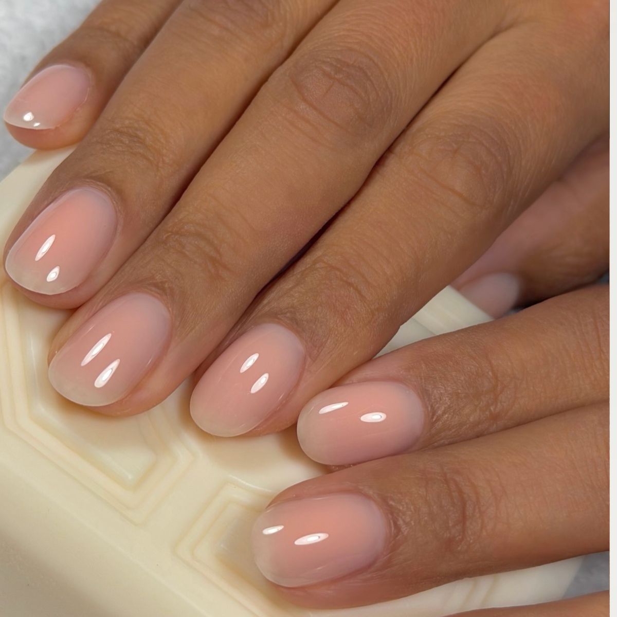A close-up photo of a pair of hands holding a bar of embossed soap