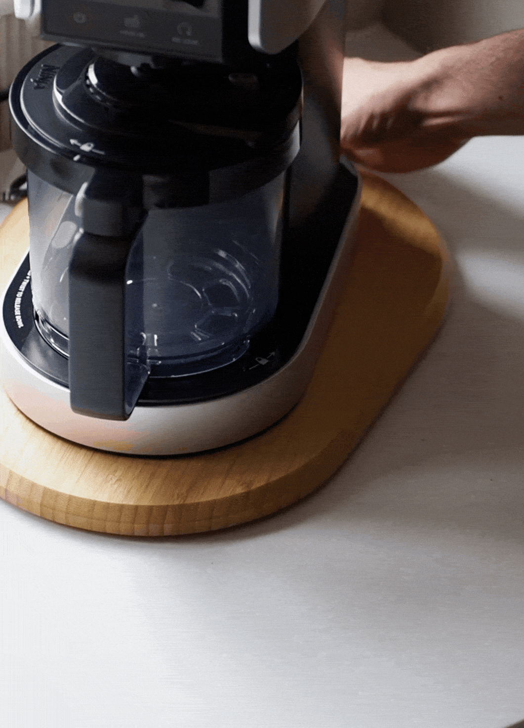 a wood board sliding on a countertop with an appliance on top