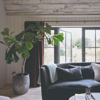 A living room with panelled walls and large windows