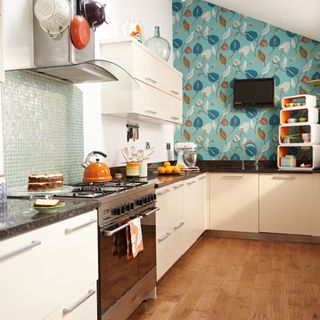 white l-shaped kitchen with abstract blue botanical wallpaper