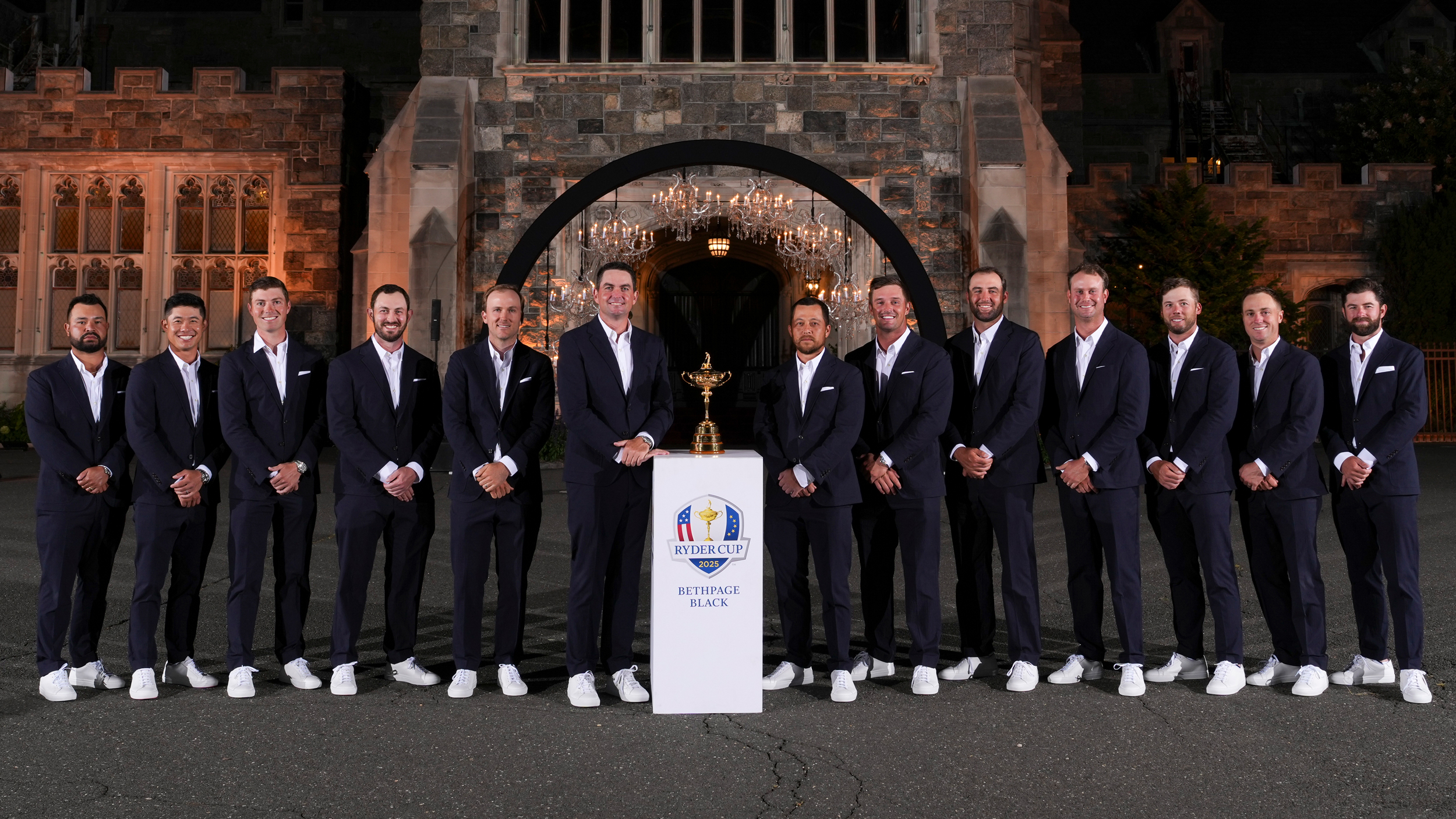 Team USA's Ryder Cup roster and captain Keegan Bradley line up either side of the Ryder Cup while wearing suits ahead of the 2025 event at Bethpage Black