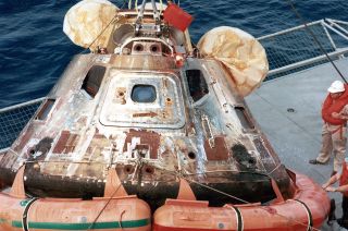 Columbia, the Apollo 11 command module, seen after its recovery from the ocean. A "RESCUE" arrow decal can be seen still affixed to the spacecraft's crew access hatch.