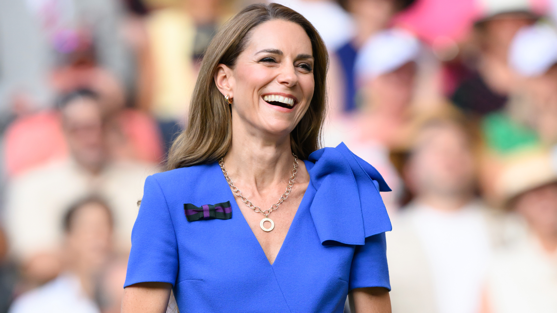 Kate Middleton laughing and wearing a blue dress at Wimbledon