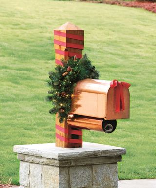 Holiday mailbox with pre-lit swag and red ribbon bow