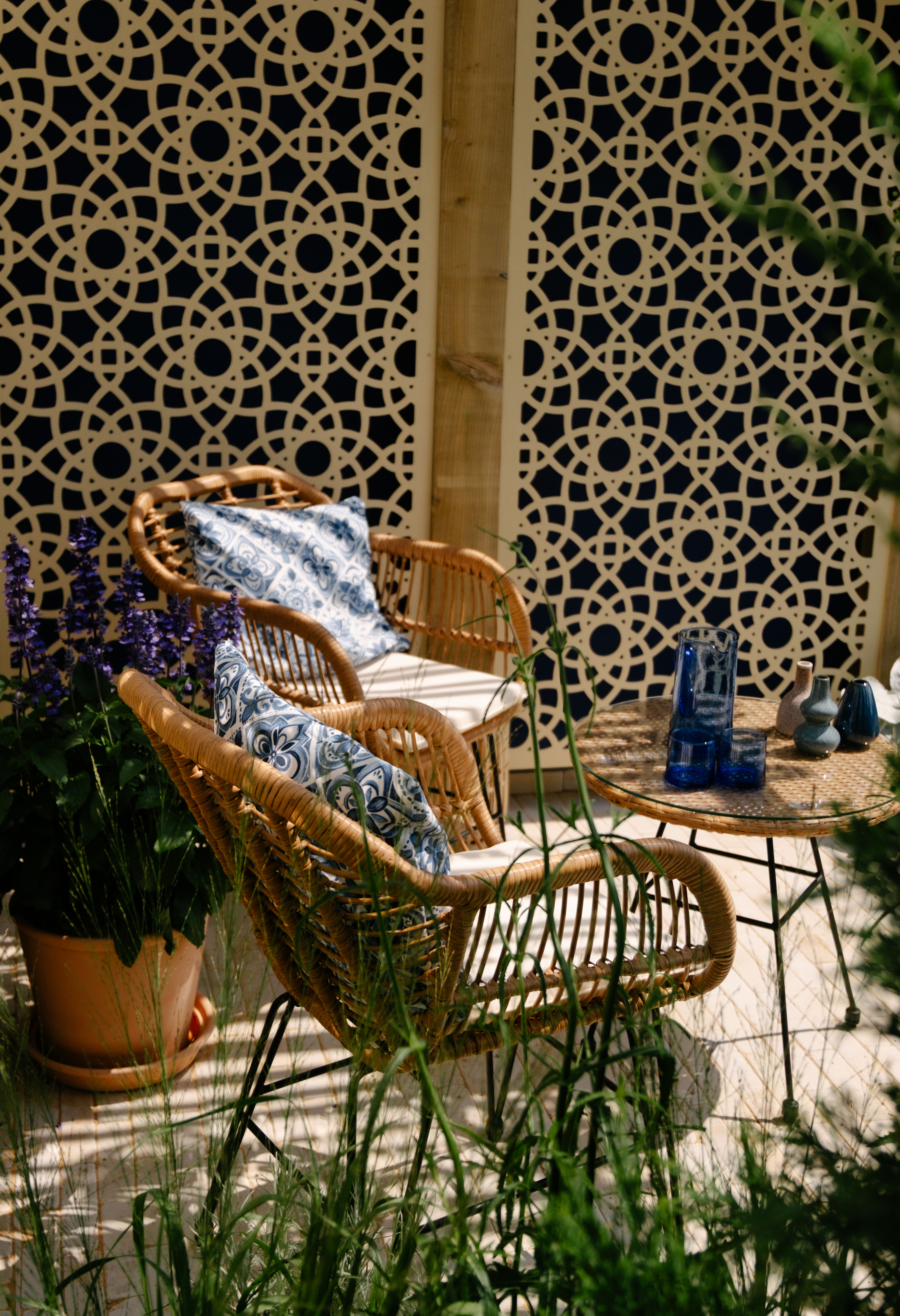 two wicker chairs surrounded by green plants