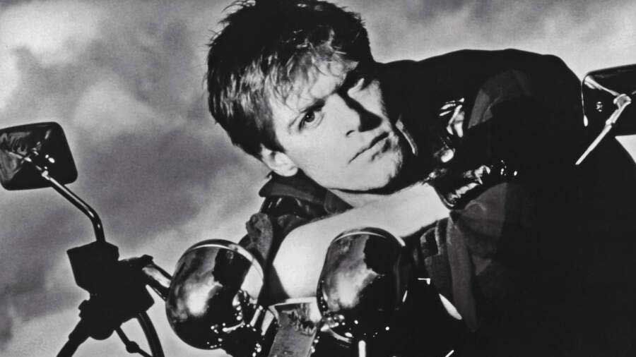 Bryan Adams leaning on a motorbike