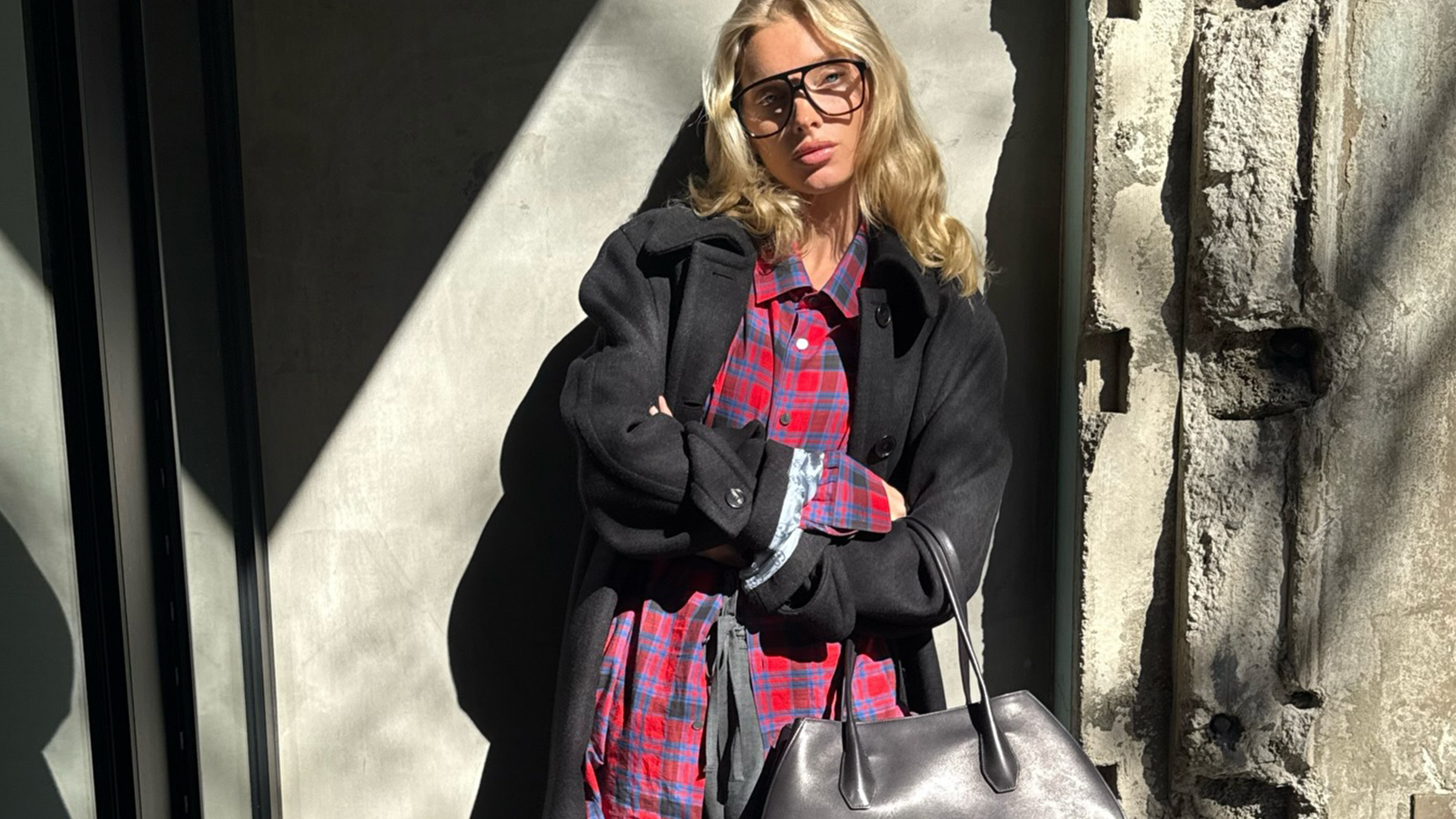 Elsa Hosk wearing a red flannel The Row shirt with a black jacket and gray tailored trousers.