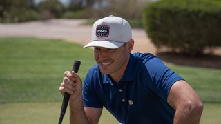 Golfer wearing a Ping Patriot hat