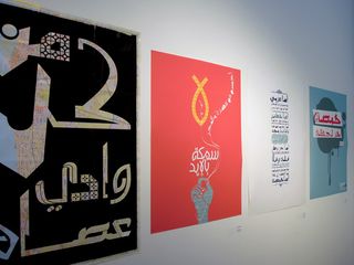 Four colourful posters featuring Arabic fonts on a white wall