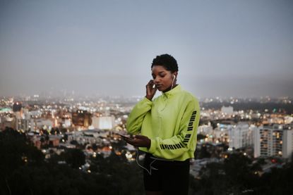 Woman listening to music from a phone, work out at night, work out before bed