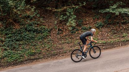 Male cyclist riding out the saddle