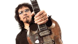 Tony Iommi holding a guitar in front of him