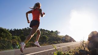 Woman running uphill on road