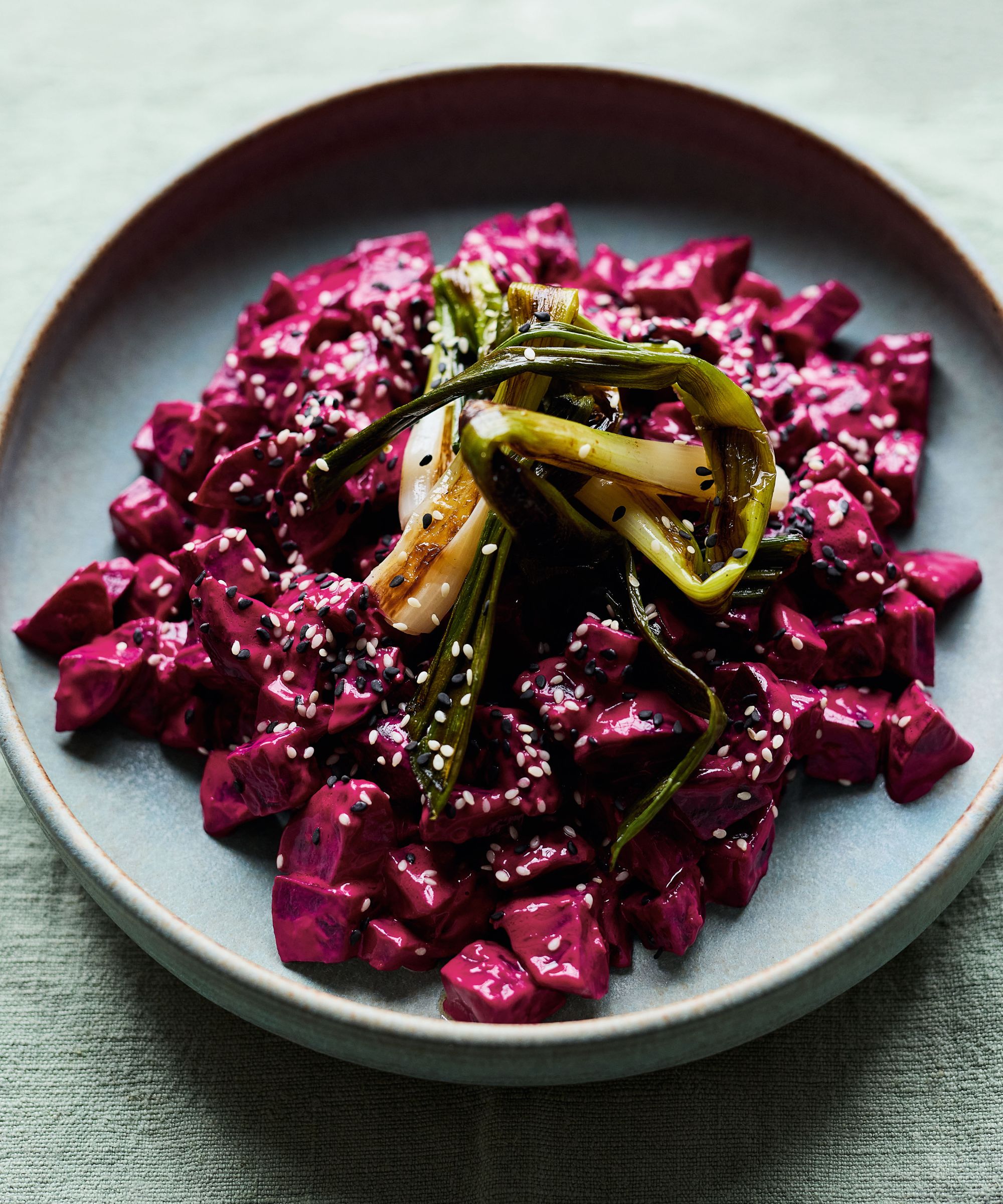 bowl of beetroot with charred spring onion and sesame seeds