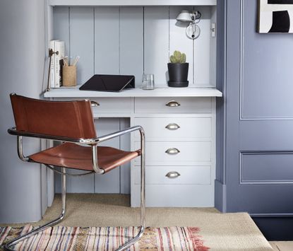 A blue painted home office with an organized desk space