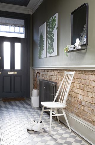 hallway with Victorian-inspired flooring, exposed brick-effect walls and large botanical prints