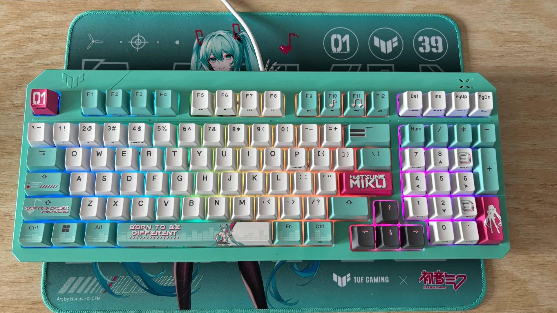 Miku x TUF Gaming Keyboard on mousemat and pale wood background