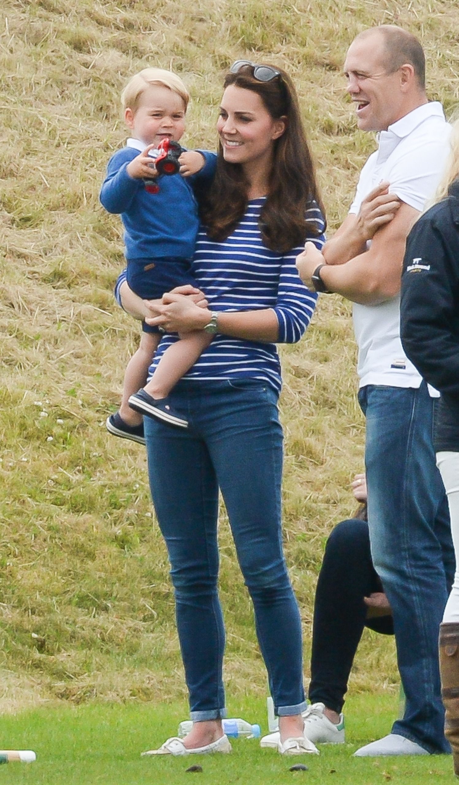 Kate Middleton holding a toddler Prince George next to Mike Tindall