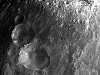 A set of three craters, nicknamed "Snowman," are seen in this image of the asteroid Vesta's northern hemisphere. This image was obtained by the framing camera on NASA's Dawn spacecraft on July 24, 2011, from a distance of about 3,200 miles (5,200 kilometers).