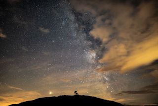 This photo depicts the photographer Ben Bush and his dog Floyd, surrounded by Mars, Saturn and the galactic core of the Milky Way galaxy. This was shot with a Nikon D810, 24mm f/1.4 lens, ISO 4000, 10sec exposure. 